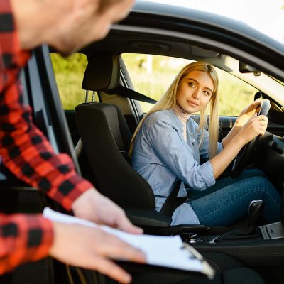 woman-in-car-looks-on-instructor-with-checklist-K8YV5PS.jpg